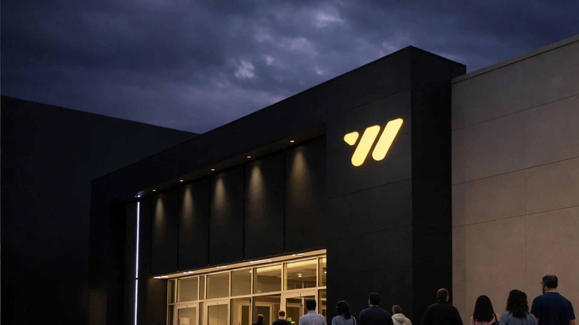 Weston Theatres exterior at dusk, the illuminated W mark on a dark facade